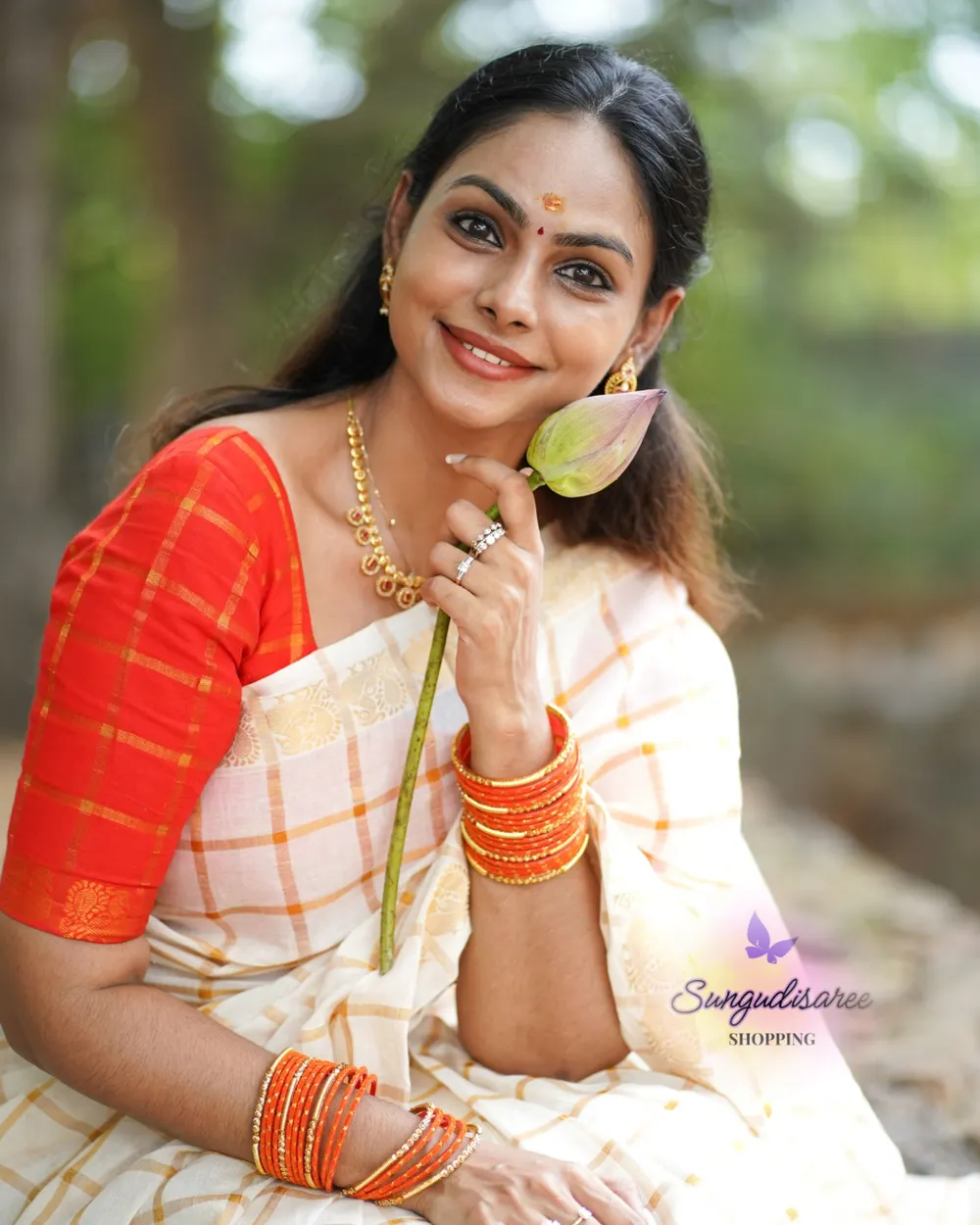 Half white saree with reddish orange blouse