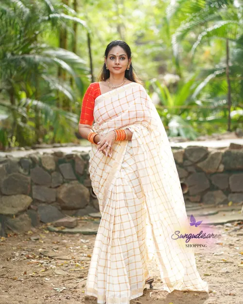 Half white saree with reddish orange blouse
